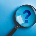 Magnifying With Question Mark is isolated on the blue background.